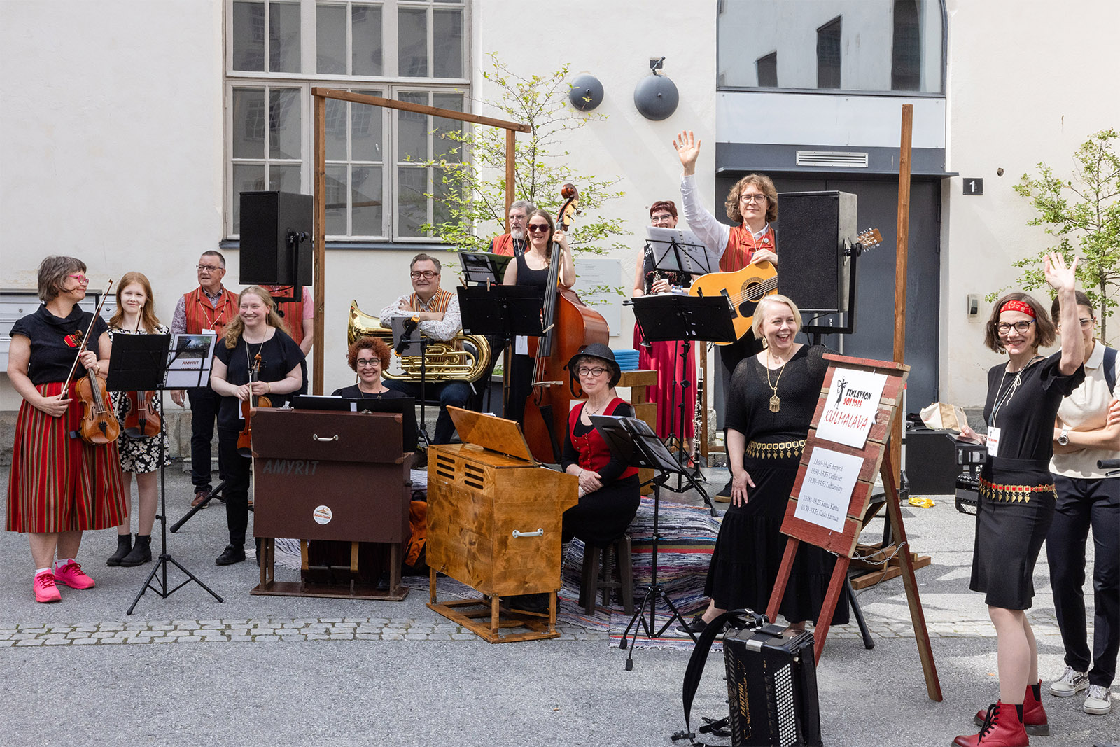 Suuri pelimanniryhmä heiluttaa ulkolavalla.