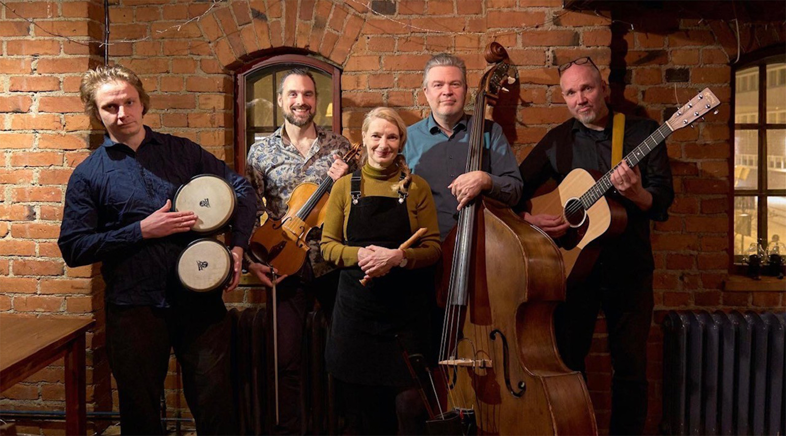 Viisi muusikkoa on asettunut yhteiskuvaan soittimiensa kanssa.